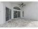 The covered patio features neutral-colored pavers, a ceiling fan, and convenient access to the house through sliding glass doors at 14006 Yellow Wood Cir, Orlando, FL 32828