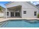 A beautiful pool with covered patio and neutral-colored exterior paint, creating a relaxing outdoor space at 14006 Yellow Wood Cir, Orlando, FL 32828