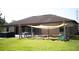 Backyard featuring a dog run, shade sail, hot tub, and a spacious lawn at 18805 Nettleton St, Orlando, FL 32833