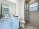Bathroom features modern vanity with stone countertops and glass enclosed shower at 235 Hampton Loop, Davenport, FL 33837