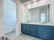 Modern bathroom with dual sinks, sleek blue cabinetry, and minimalist design, offering a clean aesthetic at 235 Hampton Loop, Davenport, FL 33837