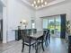 Dining room features a rustic table, modern chandelier, and sliding doors that bring in natural light at 235 Hampton Loop, Davenport, FL 33837
