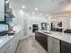Modern kitchen with stainless steel appliances, a large island, sleek countertops, and wood-look tile flooring at 235 Hampton Loop, Davenport, FL 33837