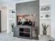 Living room with built-in shelves, dark wood entertainment center, a large TV, and modern decorative accents at 235 Hampton Loop, Davenport, FL 33837