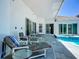 Covered patio with comfortable lounge seating next to the pool offers a relaxing outdoor living space at 235 Hampton Loop, Davenport, FL 33837