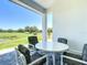 Covered patio with a table and chairs offers a view of a lush green landscape at 235 Hampton Loop, Davenport, FL 33837
