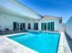 Backyard pool with a built-in spa and ample patio space, perfect for outdoor relaxation and entertainment at 235 Hampton Loop, Davenport, FL 33837