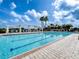 Resort-style pool with inviting lounge chairs, shade structures, and lush landscaping on a sunny day at 235 Hampton Loop, Davenport, FL 33837