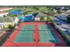 Aerial view of tennis courts with the community pool in the background and lush landscaping at 235 Hampton Loop, Davenport, FL 33837