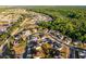An aerial view of a neighborhood with homes, a green space, and dense woods in the background at 2520 Jasmine Trace Dr, Kissimmee, FL 34758