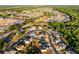 An aerial view of a residential area featuring homes, a lake, and forest in the background at 2520 Jasmine Trace Dr, Kissimmee, FL 34758