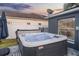 Backyard features a hot tub on a stone patio, with string lights and privacy fence at 2520 Jasmine Trace Dr, Kissimmee, FL 34758