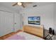 Bright view of this bedroom featuring a TV, a dresser, and wood flooring at 2520 Jasmine Trace Dr, Kissimmee, FL 34758