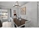 Dining area featuring a wood table, white chairs, and modern light fixture at 2520 Jasmine Trace Dr, Kissimmee, FL 34758