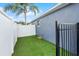 Backyard dog run features a black iron fence and lush, low-maintenance artificial turf at 2520 Jasmine Trace Dr, Kissimmee, FL 34758
