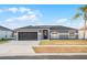 Attractive single-story home featuring a dark garage door, neutral paint, and a well-manicured lawn at 2520 Jasmine Trace Dr, Kissimmee, FL 34758