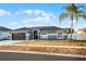 Attractive single-story home featuring a dark garage door, neutral paint, and a well-manicured lawn at 2520 Jasmine Trace Dr, Kissimmee, FL 34758