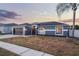 Attractive single-story home featuring a dark garage door, neutral paint, and a well-manicured lawn at 2520 Jasmine Trace Dr, Kissimmee, FL 34758