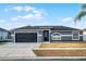 Attractive single-story home featuring a dark garage door, neutral paint, and a well-manicured lawn at 2520 Jasmine Trace Dr, Kissimmee, FL 34758