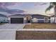 Charming single-story home featuring a dark gray garage door, neutral paint, and a well-manicured lawn at 2520 Jasmine Trace Dr, Kissimmee, FL 34758