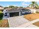 Beautiful single-story home with a two-car garage, lush landscaping, and a welcoming entrance at 2520 Jasmine Trace Dr, Kissimmee, FL 34758