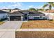 Inviting single-story home with a two-car garage, stone driveway, and manicured lawn at 2520 Jasmine Trace Dr, Kissimmee, FL 34758