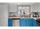 Bright kitchen featuring stainless steel appliances, blue lower cabinets and open sink at 2520 Jasmine Trace Dr, Kissimmee, FL 34758
