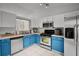Charming kitchen with stainless steel appliances, and blue lower cabinets at 2520 Jasmine Trace Dr, Kissimmee, FL 34758