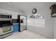 Bright kitchen features stainless steel appliances, white and blue cabinets, and tile flooring at 2520 Jasmine Trace Dr, Kissimmee, FL 34758