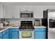 Updated kitchen with stainless steel appliances and blue lower cabinets at 2520 Jasmine Trace Dr, Kissimmee, FL 34758