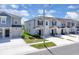 An eye-level view of new townhomes featuring a gray color palette and well manicured lawns at 2845 Pierr St, Davenport, FL 33837