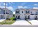 Exterior view of the townhomes with a well-maintained lawn and a concrete driveway at 2845 Pierr St, Davenport, FL 33837