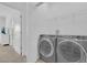 Bright laundry room featuring modern washer and dryer and upper shelving for storage at 2845 Pierr St, Davenport, FL 33837