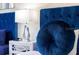 A close-up showcasing a plush blue headboard, decorative pillow, and modern nightstand with lamp at 2908 Sunset Lakes Blvd, Kissimmee, FL 34747