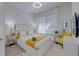 Bright bedroom featuring a luxurious white bed with yellow accents and modern decor at 2908 Sunset Lakes Blvd, Kissimmee, FL 34747