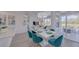 Bright dining area features modern chandelier, large sliding glass doors and stylish teal chairs, perfect for entertaining at 2908 Sunset Lakes Blvd, Kissimmee, FL 34747