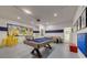 Bright, inviting game room has a mural, pool table, and foosball at 2908 Sunset Lakes Blvd, Kissimmee, FL 34747