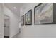 A brightly lit hallway is decorated with framed art and leads to a laundry room at 2908 Sunset Lakes Blvd, Kissimmee, FL 34747
