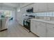 Bright kitchen featuring white cabinets, quartz countertops, stainless steel appliances, and modern backsplash at 2908 Sunset Lakes Blvd, Kissimmee, FL 34747