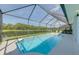 A screened in pool area offers a beautiful view of the backyard pond at 2908 Sunset Lakes Blvd, Kissimmee, FL 34747