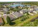 Aerial view showcasing neighborhood homes, mature trees, and a scenic pond with a fountain at 3641 Bristol Cove Ln, St Cloud, FL 34772