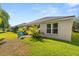 Landscaped backyard featuring a small patio area with seating, lush lawn, and manicured plants at 3641 Bristol Cove Ln, St Cloud, FL 34772