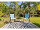 Outdoor seating area with two patio chairs, a black and white rug, and lush green surroundings at 3641 Bristol Cove Ln, St Cloud, FL 34772
