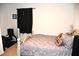 Bedroom with a bed, dark curtains, and basic furnishings, offering a simple and cozy space at 3673 Caspian St, Leesburg, FL 34748