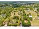 A sprawling aerial view showcases a home with a private pond, long driveway, and lush landscape at 3720 Edsel Ave, St Cloud, FL 34772