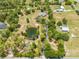 Aerial view showcasing a home with a private pond, long driveway, and surrounding trees at 3720 Edsel Ave, St Cloud, FL 34772