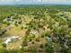 Wide aerial view of a home with a private pond, expansive land, and lush surrounding trees at 3720 Edsel Ave, St Cloud, FL 34772