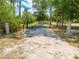 Gated entrance to a private driveway with tall trees and lush greenery surrounding the property at 3720 Edsel Ave, St Cloud, FL 34772