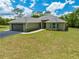 Inviting single-story home featuring a two-car garage, nestled on a vibrant green lawn under a sunny sky at 3720 Edsel Ave, St Cloud, FL 34772