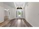 Bright foyer with wood-look flooring, a modern chandelier, and an arched transom window above the front door at 3720 Edsel Ave, St Cloud, FL 34772